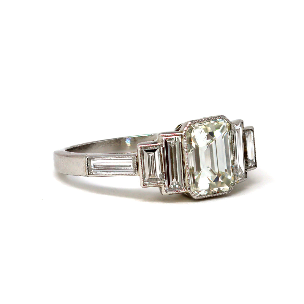An Elegant Emerald-cut Diamond Ring with side baguettes set in Platinum angle view