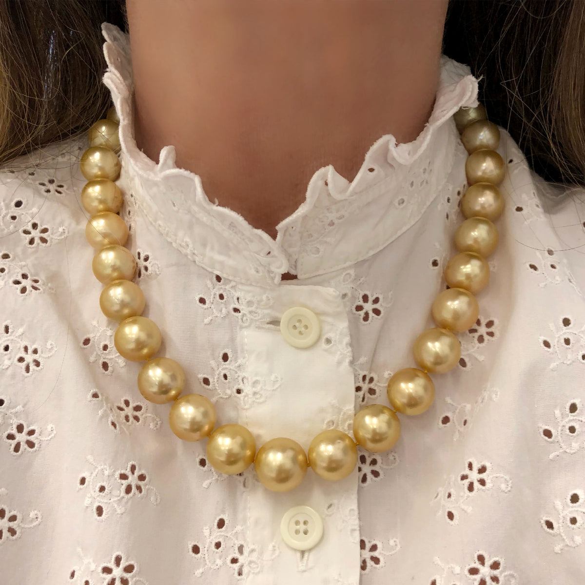natural south sea gold pearl necklace with 14 karat yellow gold diamond clasp model white background view